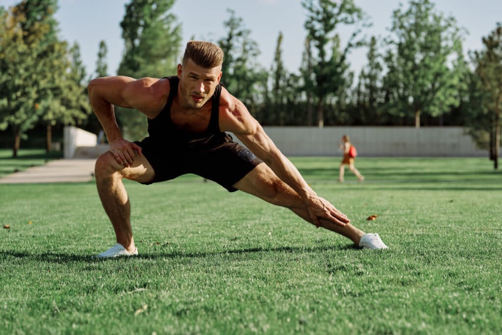 sports man doing exercises on the lawn in the park