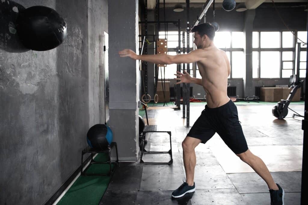 man throwing medicine ball at the gym