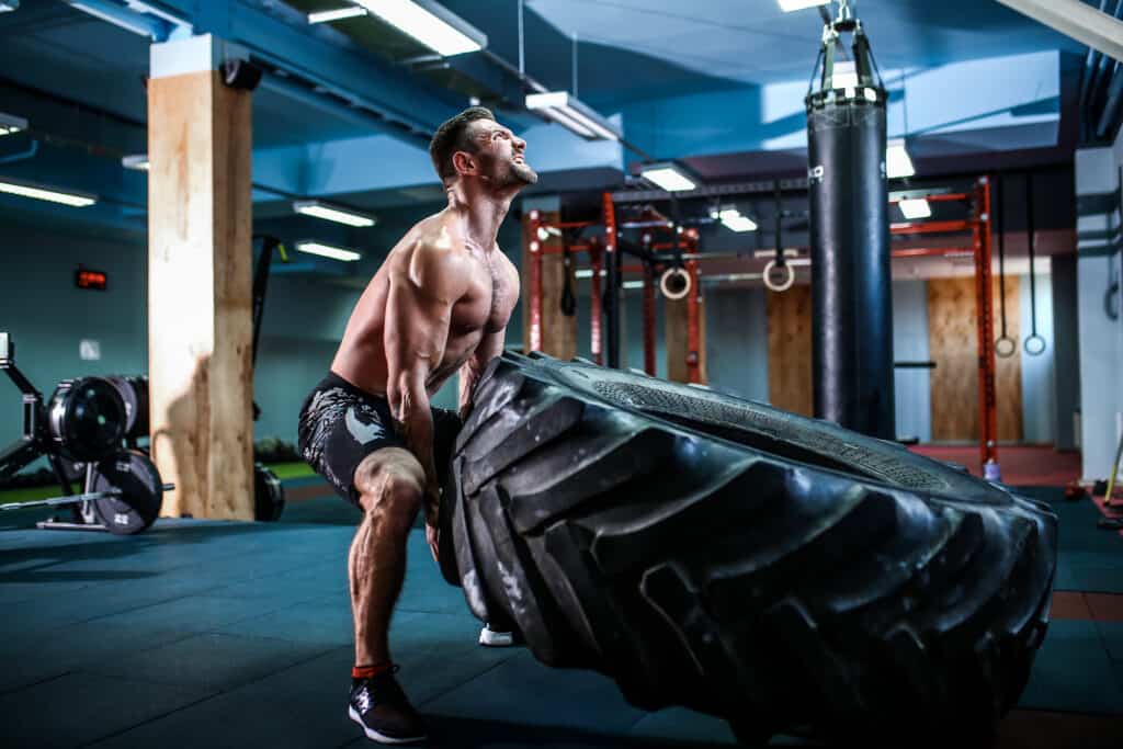 man trying to lift heavy tire