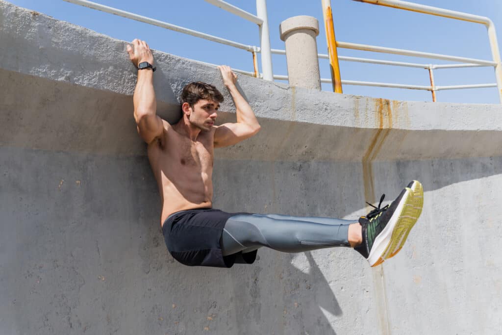 man holding onto ledge to work out