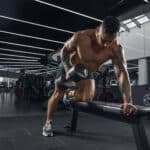 muscular man lifting dumbbell at gym