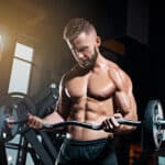 man doing bicep curls with ez-bar