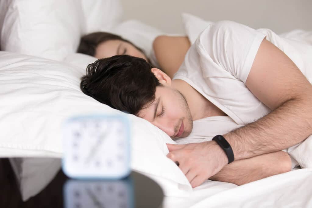 couple trying to sleep with smart watch