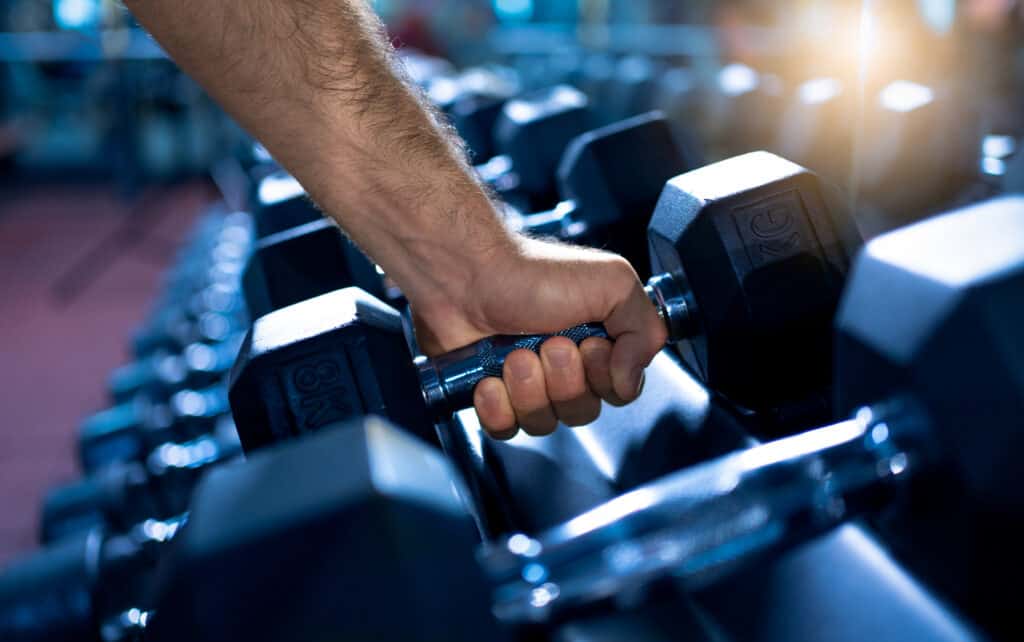 man grabbing dumbbell