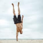 man doing one handed handstand