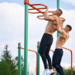 men doing pull-ups at outdoor gym