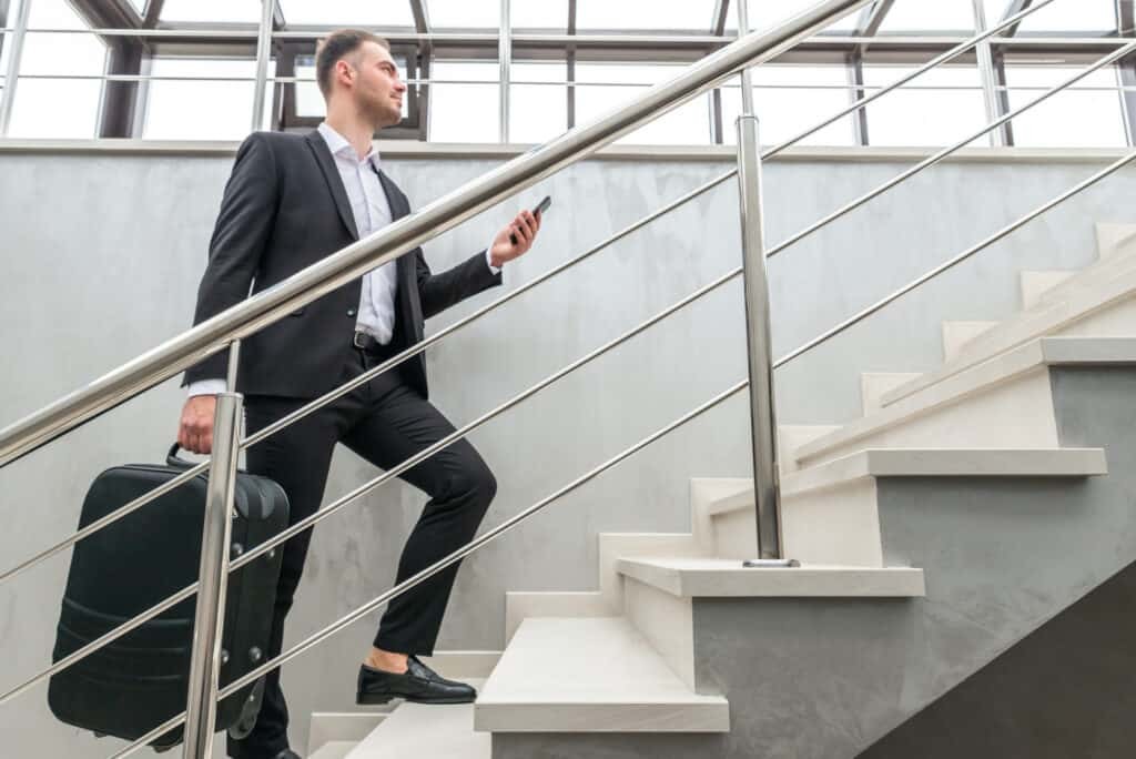 businessman walking up stairs with suitcase