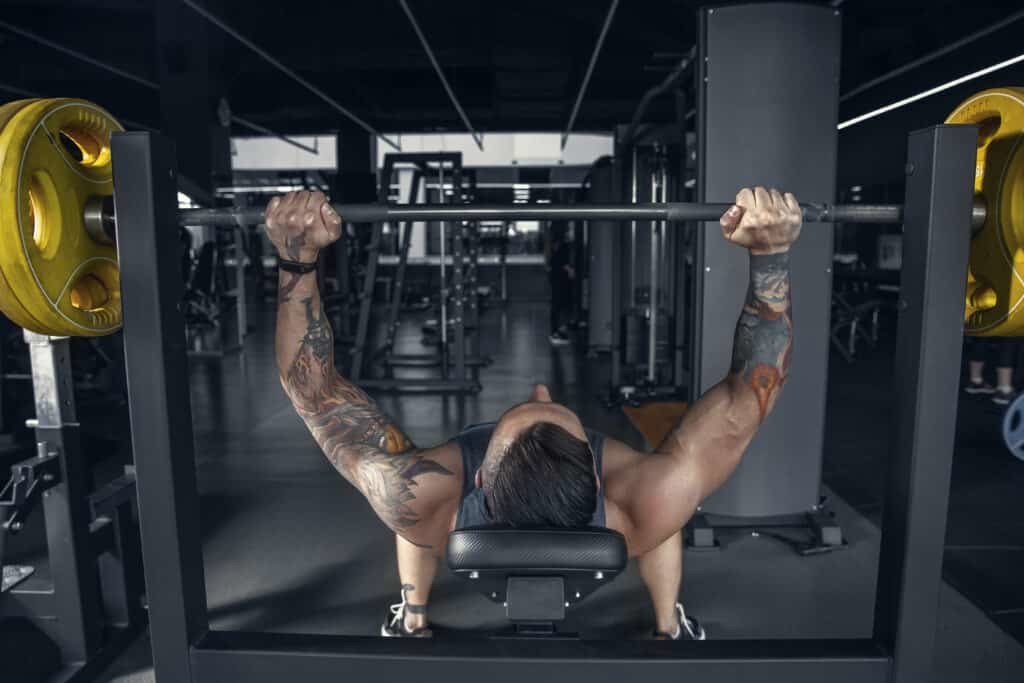 man practicing pull ups with barbell