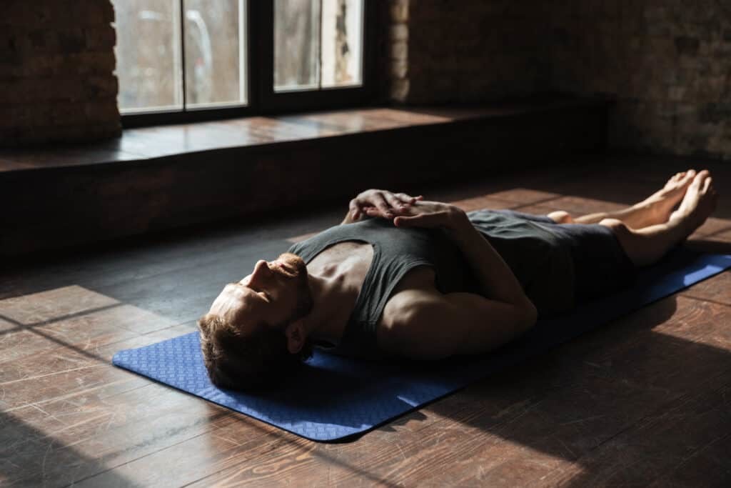 man lying on yoga mat