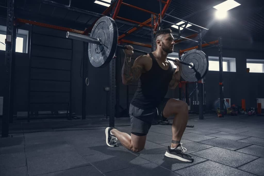 man doing barbell lunges