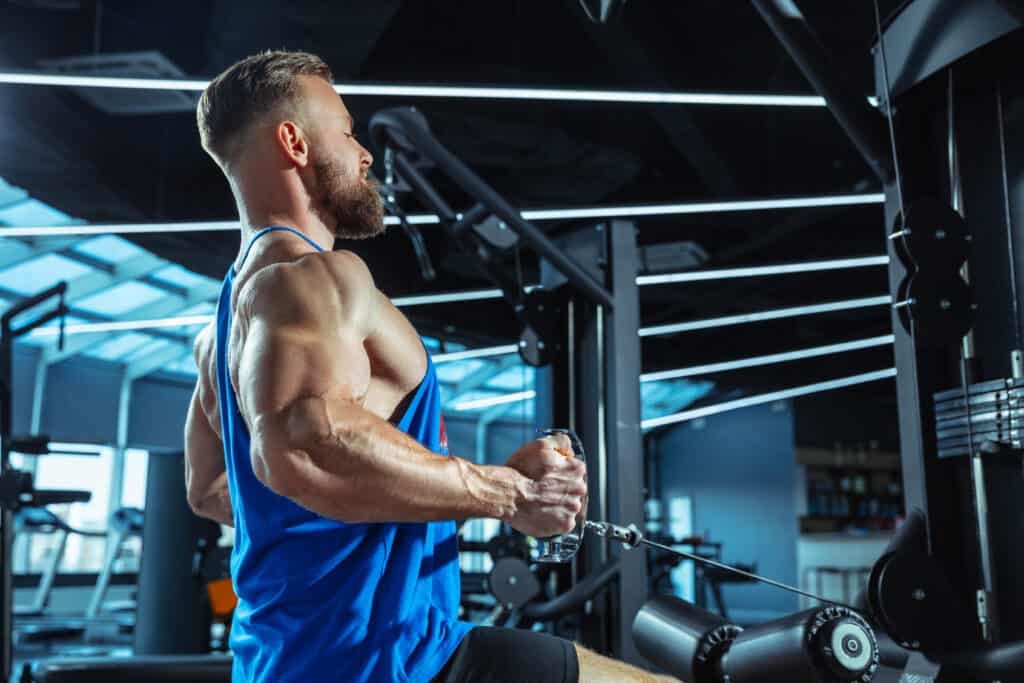 man doing strength training exercises at the gym