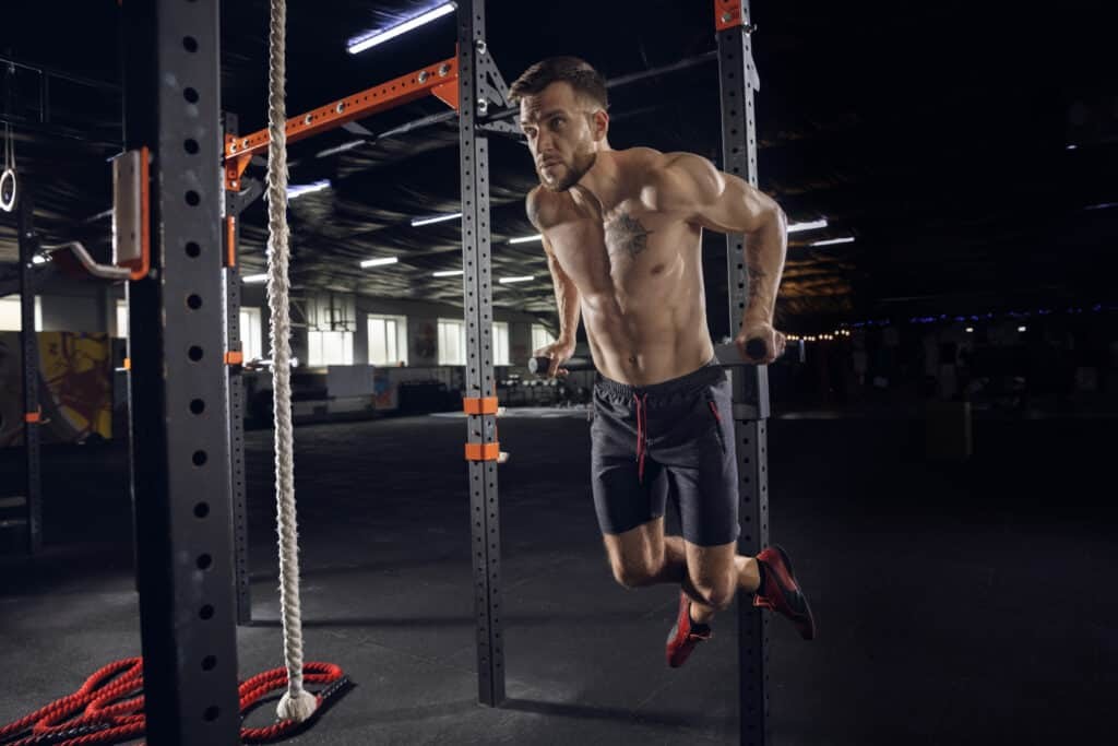 man doing pull ups at the gym