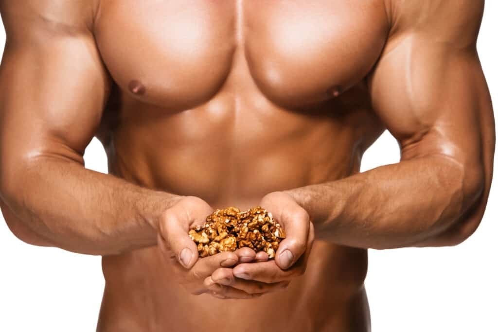muscular man holding walnuts