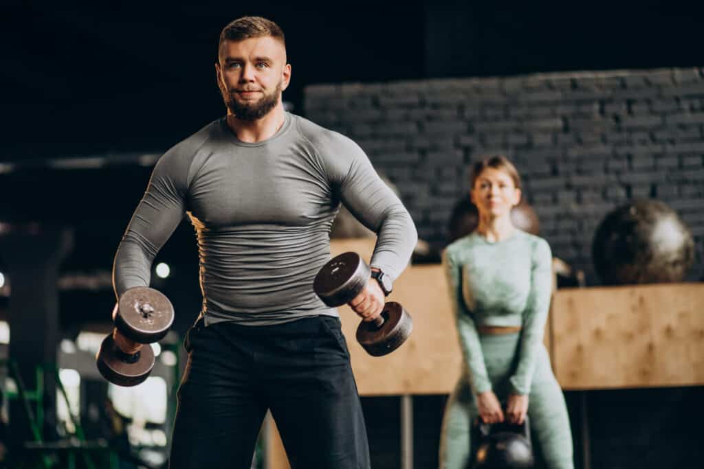 couple lifting dumbbells and kettlebell