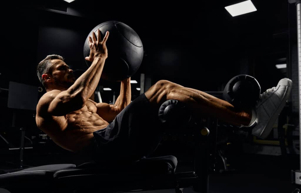 man doing crunch with medicine ball