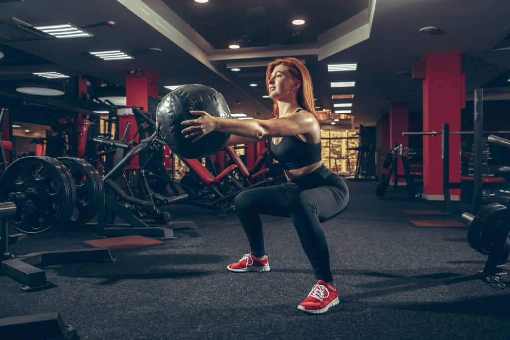 woman working out with medicine ball at the gym