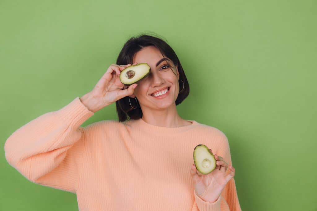 woman holding healthy avocado