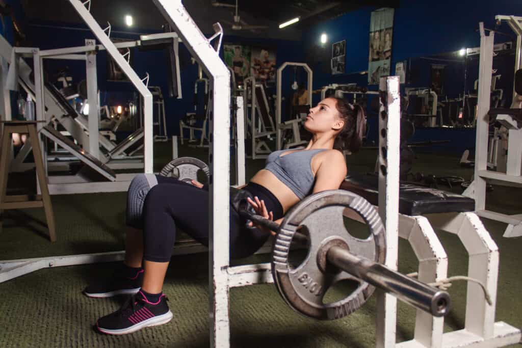 woman doing glute exercises with barbell