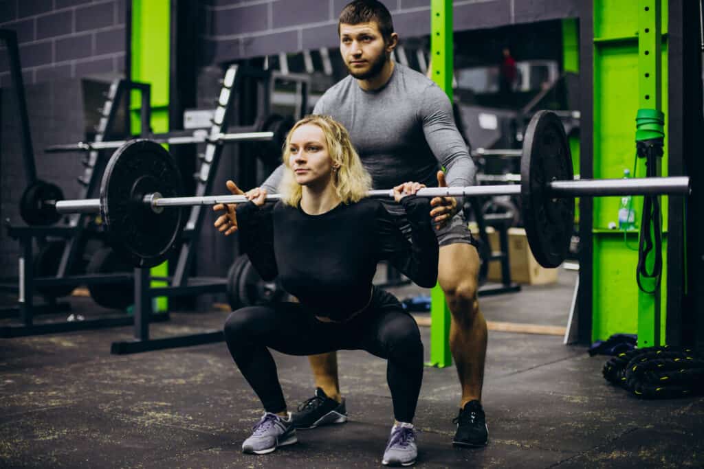 Couple training at the gym with a barbell