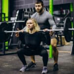 Couple training at the gym with a barbell