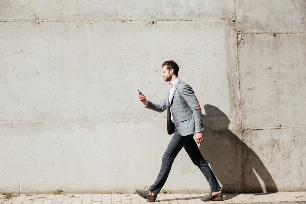 man walking looking at phone