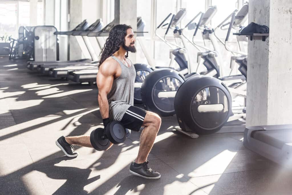 man doing dumbbell lunges
