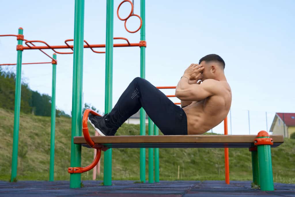 man doing crunches at outdoor gym