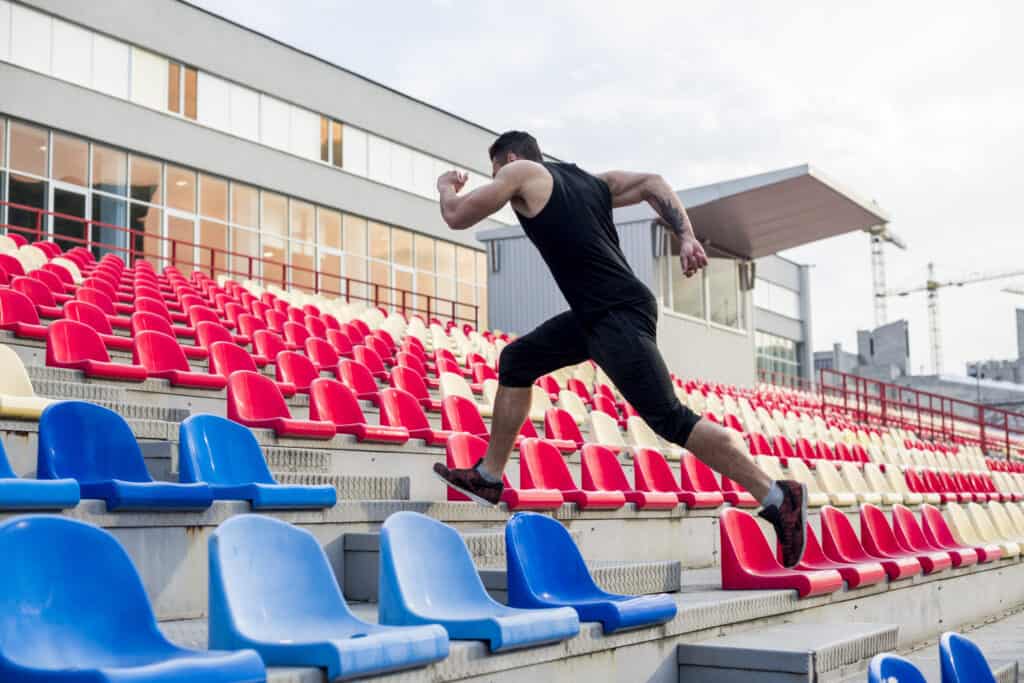 man running up stadium steps