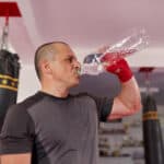 man dirnking water after training