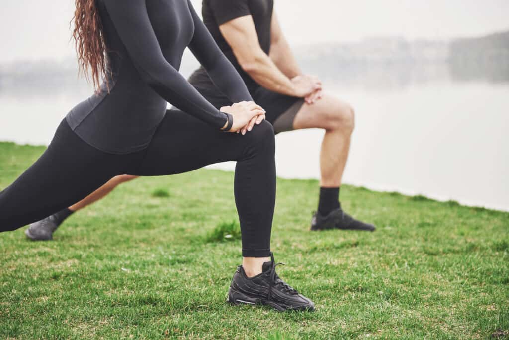 Couple stretching their hamstrings