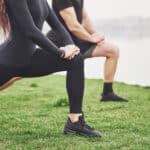 Couple stretching their hamstrings