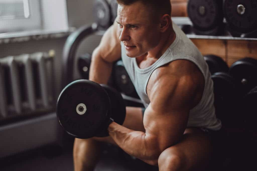 muscular man doing bicep curls at home