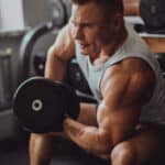 muscular man doing bicep curls at home