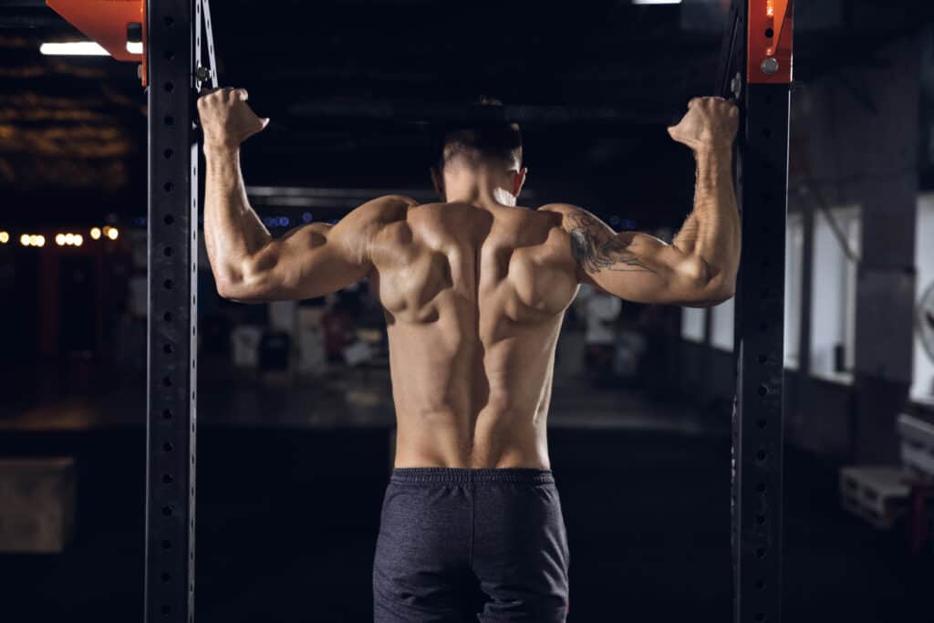 man performing pull-ups at the gym