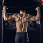 man performing pull-ups at the gym