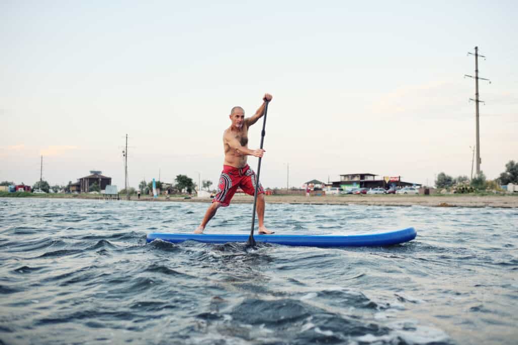 man paddle-boarding in choppy waters