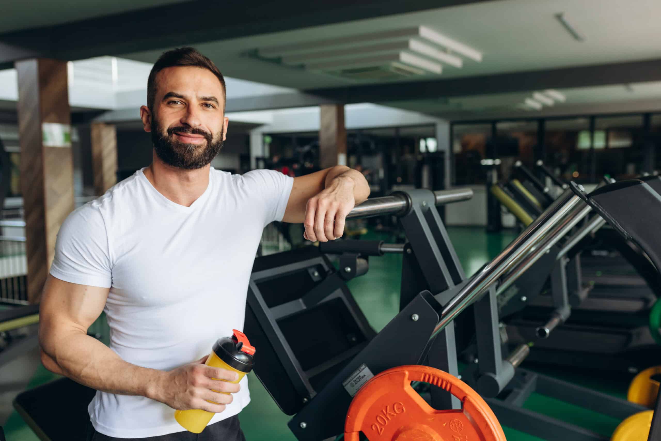 man drinking protein shake during rests at gym