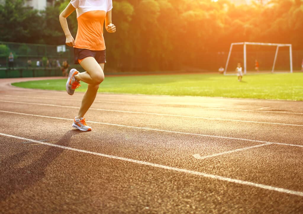 Athletic woman running on track