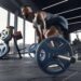 man doing deadlift with barbell at the gym