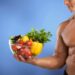 man holding bowl of healthy fruit